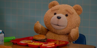 Ted sat in a cafeteria, doing a thumbs-up gesture