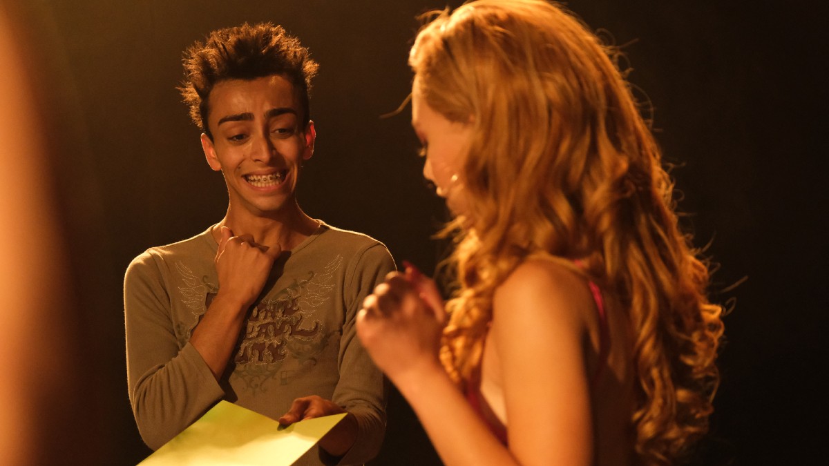 Mimi looking at a piece of paper held by Steevyshady in Queens of Drama.