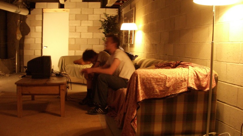 Two people sitting on a sofa in Secret Mall Apartment.