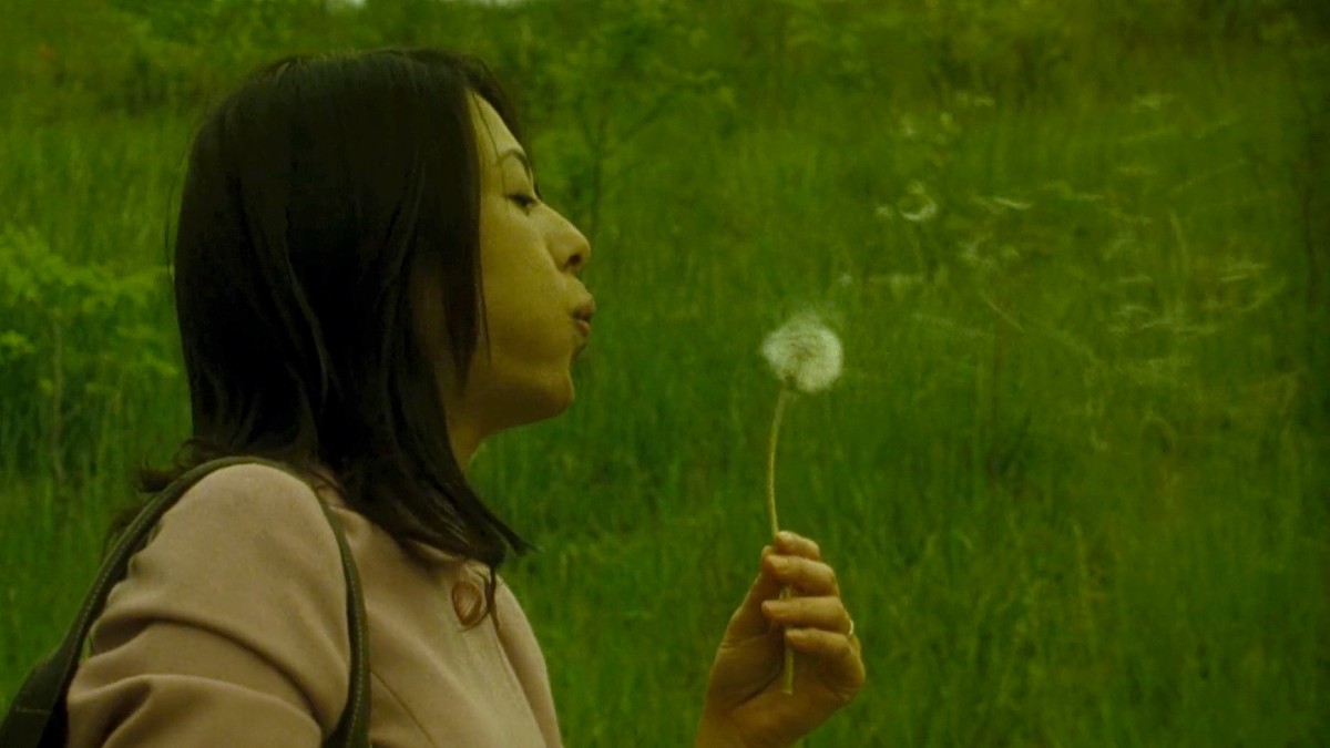 Ko blowing a dandelion in Hanging Garden.