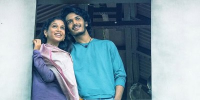 The two lead characters sat by a window ledge in Band Melam.